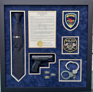 Custom memorabilia shadow box in Pembroke Pines displaying a certificate, badge, and meaningful personal items.